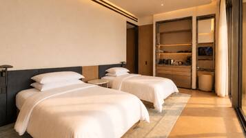 Een hotelkamer met twee bedden, een klein rond tafeltje, een kledingkast en een badkamer.