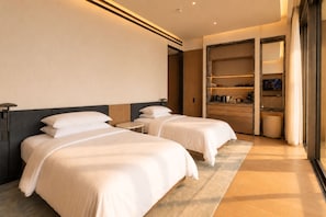 Une chambre d’hôtel avec deux lits, une petite table ronde, une armoire et une salle de bain.