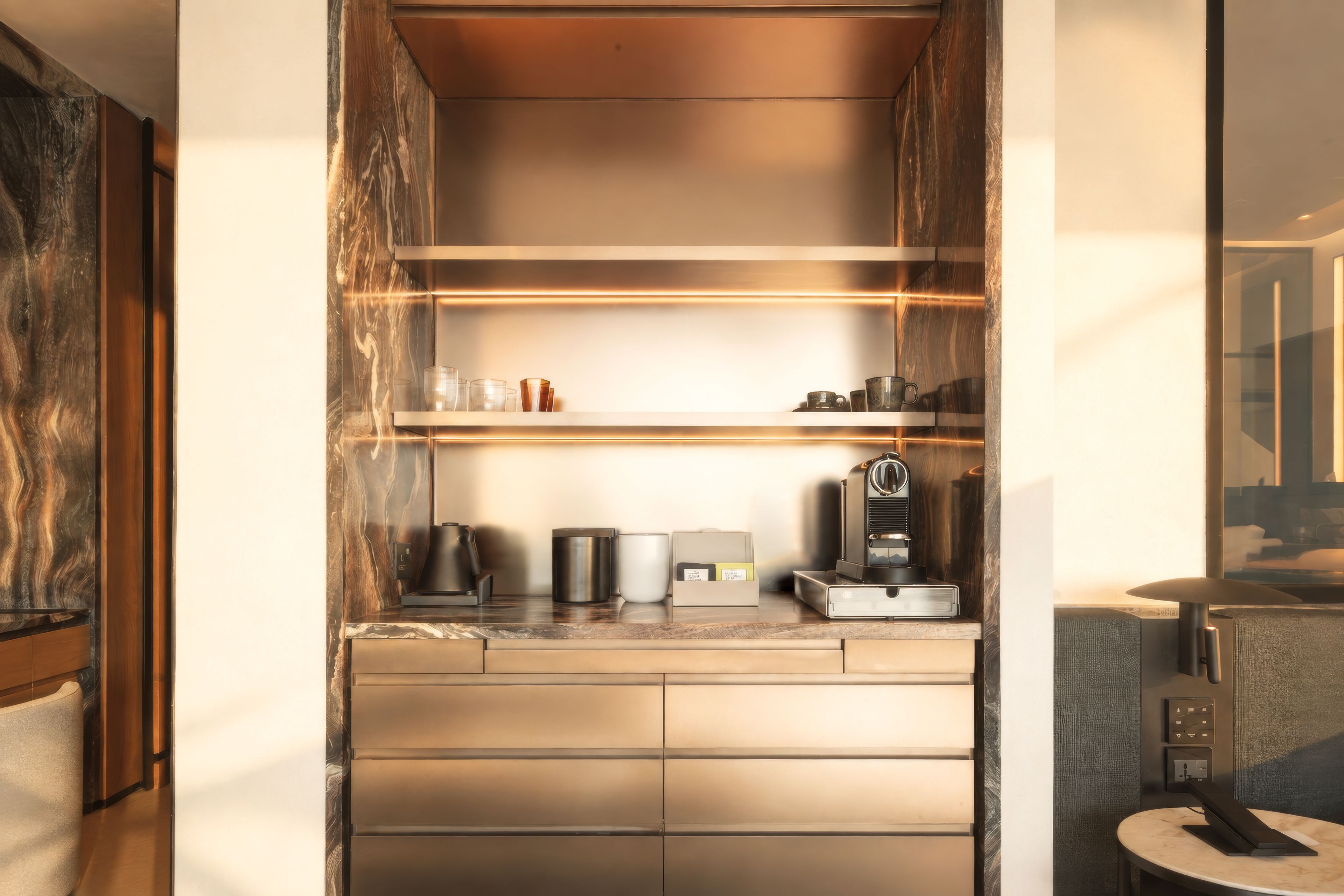 A compact kitchen with built-in appliances, a coffee machine, and a small countertop.