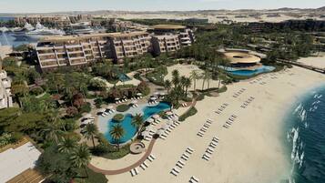 Een resort met meerdere zwembaden, een strand en een jachthaven met jachten.