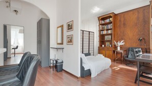 Una sala moderna con un sofá, una cama, una estantería y un comedor.