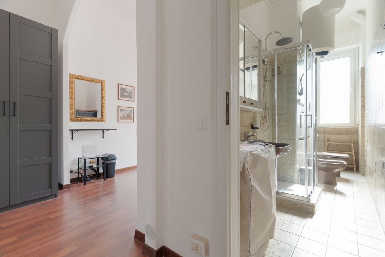 Un bagno con doccia vetrata, un water e un lavandino.