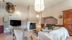 Una sala de estar con un trofeo de caza en la pared, una chimenea, un televisor y un sofá.