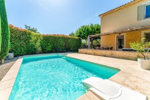 A swimming pool with a tiled deck, a pergola, and a stone wall. - Holiday Home 'Villa Les Joncs D'Octobre' with Private Pool, Wi-Fi and Air Conditioning (Jonquerettes)
