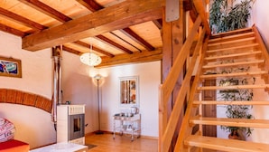A wooden interior with a staircase, a fireplace, and a dining area. - Casa dei Ciliegi (Bagni di Lucca)