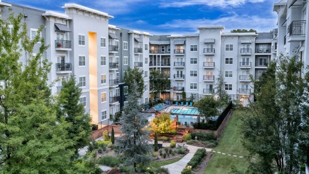 A multi-story residential building with balconies, a swimming pool, and landscaped gardens. - New 2-bedroom corporate loft in charming Atlanta, right by the airport. (Atlanta)