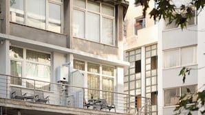 A multi-story building with balconies, large windows, and outdoor seating. - Estia Premium Apartments - Superior Suite Vackhou 1 #1.2 (Thessaloniki)