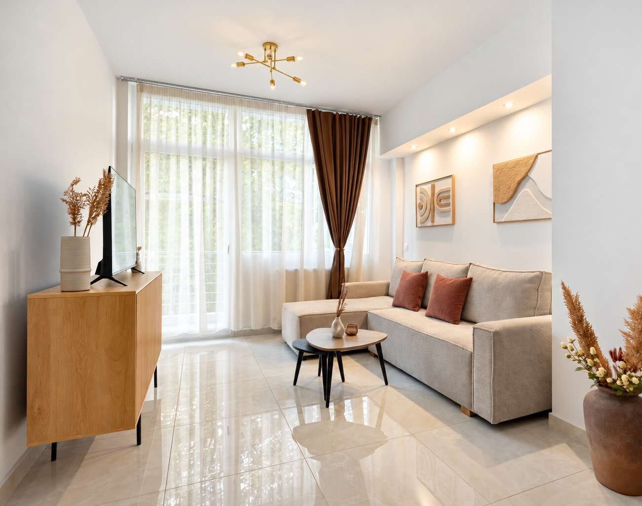 A Space to Unwind: Stretch out on the corner sofa opposite the TV, with a coffee table close at hand. Daylight filters through sheer curtains, while wooden surfaces and decorative touches offer a cosy atmosphere for relaxing after exploring the city.