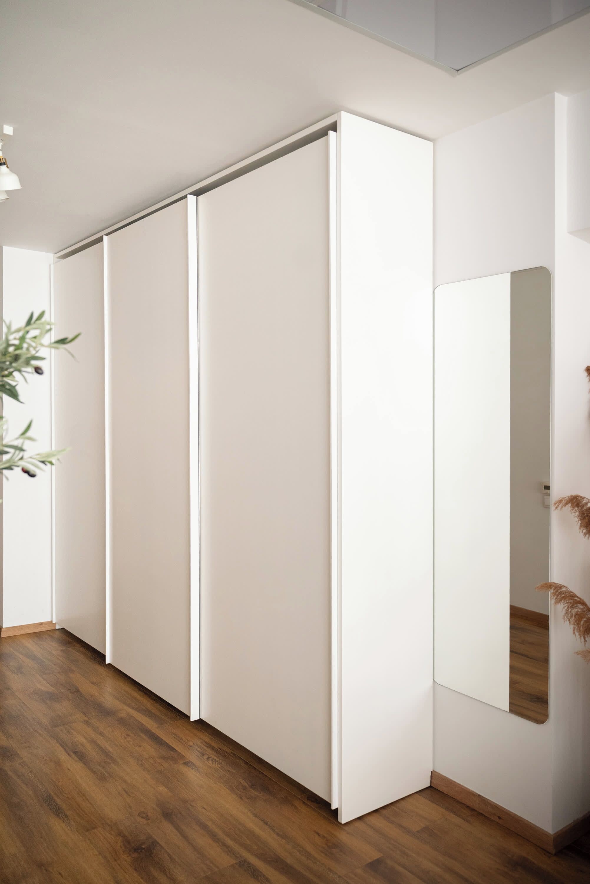 A room with a sliding door, a mirror, and a wooden floor.