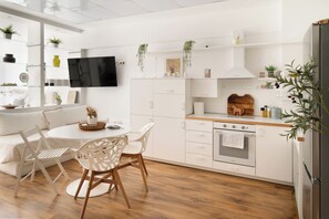 Eine moderne Küche mit weißen Schränken, einem Holzespeisetisch und Stühlen.