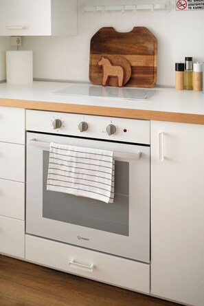 A kitchen with a white oven, a wooden cutting board with a cookie cutter, and a white towel hanging on the oven door. - Estia Premium Apartments - 80 Squaremeter Cozy Loft City Center (Thessaloniki)