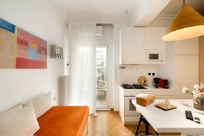 A compact living space with a kitchenette, a dining area, and a seating area. - Estia Premium Apartments - Honey Paleon Patron Germanou (Thessaloniki)