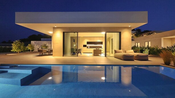 Una casa moderna con piscina, comedor y sala de estar con sofá.