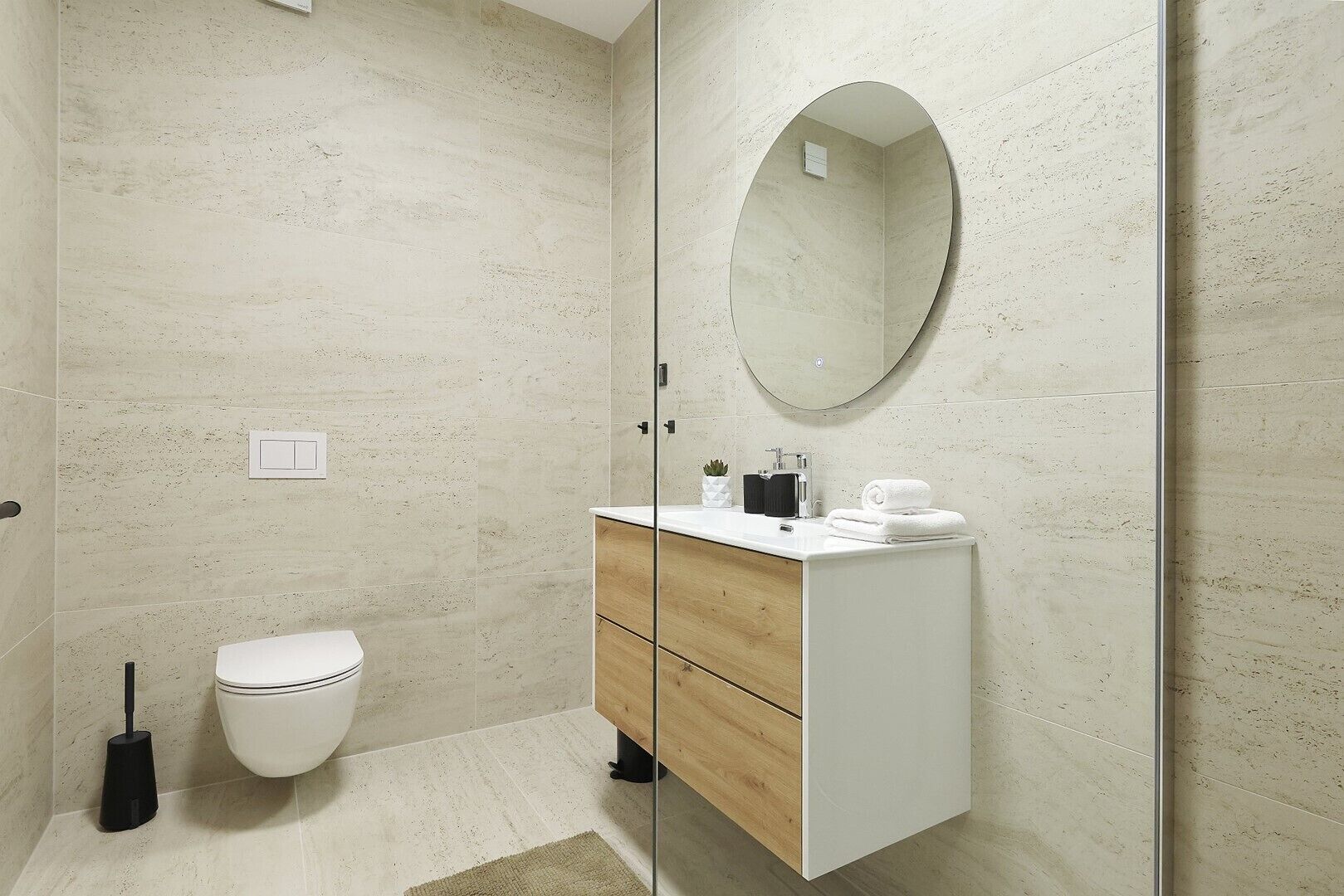 Une salle de bain comprenant des toilettes, un lavabo avec un miroir et un espace douche.
