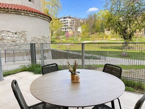 A round table with chairs, a potted plant, and a stone wall. - Kajetanka Residence - with terrace and free parking on weekends (Hlavní město Praha)