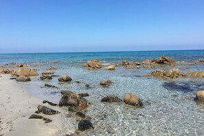 A beach with clear water, rocks, and a clear sky. - ANFITEATRO 39 - BUDONI SWEET HOME (Porto Ottiolu)