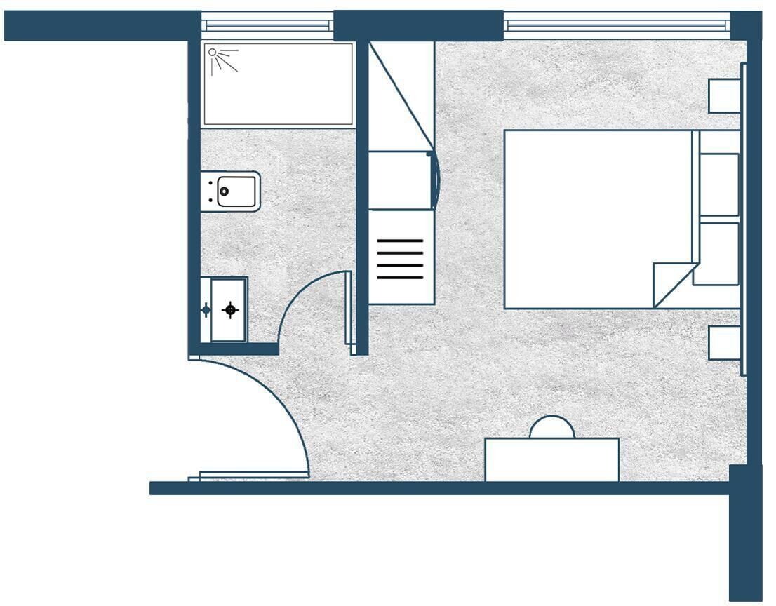 A hotel room layout with a bed, a desk, a chair, a wardrobe, and a bathroom.