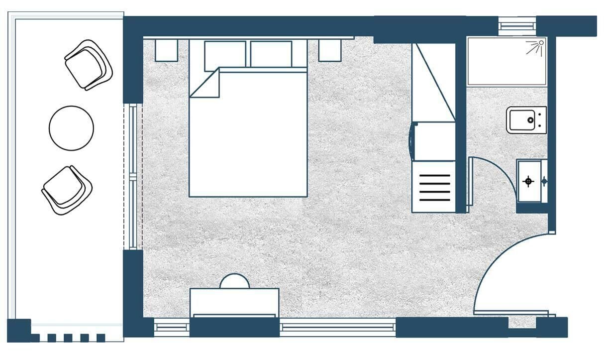 A hotel room layout with a bed, a desk, a chair, a small table, and a sofa.