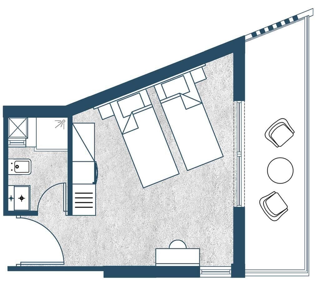 Distribución de una habitación de hotel con cama, escritorio, silla, armario y baño pequeño.