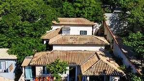 A residential area with multiple houses featuring tiled roofs and surrounded by lush greenery. - House in Geribá, 5 minutes from the beach, with pool, sleeps 26. (Armação  dos Búzios)