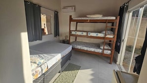 A small room with a single bed, a bunk bed, a window, and a door. - House in Geribá, 5 minutes from the beach, with pool, sleeps 26. (Armação  dos Búzios)