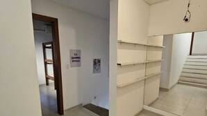 A hallway with a white wall, a door, and a sign that reads 'SEJA PROPRIA INFORMAÇÃO'. - House in Geribá, 5 minutes from the beach, with pool, sleeps 26. (Armação  dos Búzios)