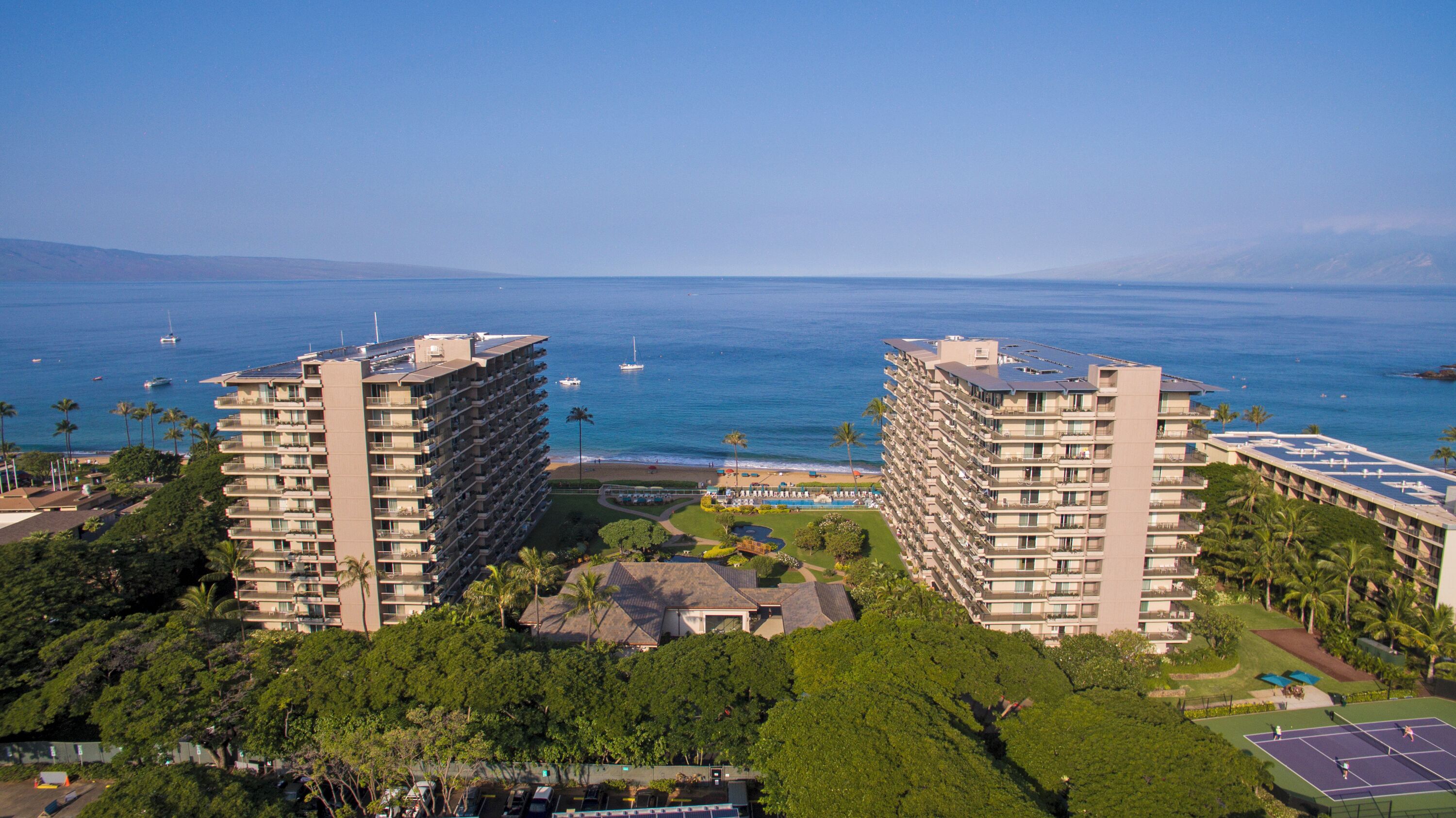 Un hôtel de grande hauteur, avec de nombreux étages, une piscine et une vue sur l’océan.