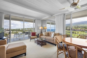 Ein geräumiger Balkon mit Blick auf eine weite Landschaft, eine gemütliche Sitzecke mit Sofa und Sesseln sowie ein Glastisch.