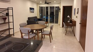A modern living room with a dining area, a ceiling fan, and a sliding glass door leading to a balcony. - 1. BEAUTIFUL APARTMENT JUST A FEW STEPS FROM THE BEACH (Progreso)
