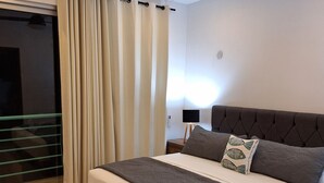 A bedroom with a bed, a ceiling fan, a nightstand, and a window with curtains. - 1. BEAUTIFUL APARTMENT JUST A FEW STEPS FROM THE BEACH (Progreso)