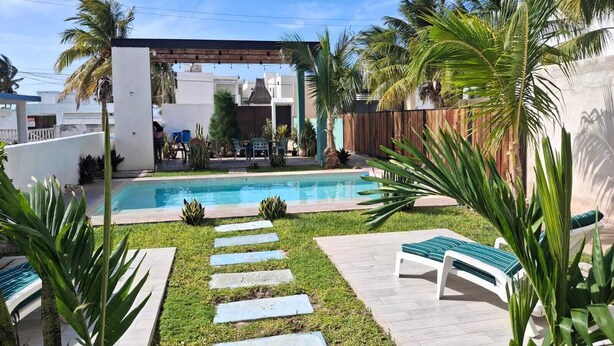 A backyard with a swimming pool, stone steps, and lounge chairs. - 1. BEAUTIFUL APARTMENT JUST A FEW STEPS FROM THE BEACH (Progreso)