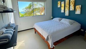 Een slaapkamer met een bed, een raam met uitzicht en wanddecoratie.