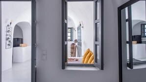 An open door leading to a room with a window, a white wall, and a visible interior. - Noelia Suites - Cave by ΜΡS (OIA)