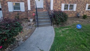 A two-story brick building with a front entrance, a small porch, and a front yard with a sidewalk leading to the entrance. - Fabulous 3-bedroom house with AC in charming Jonesboro (Jonesboro)