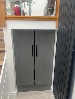 A grey wardrobe with two doors and a wooden shelf above. -    Couples Retreat in North Cumbria,w Logburner, Enclosed Terrace, Walks& Pub (Brampton)