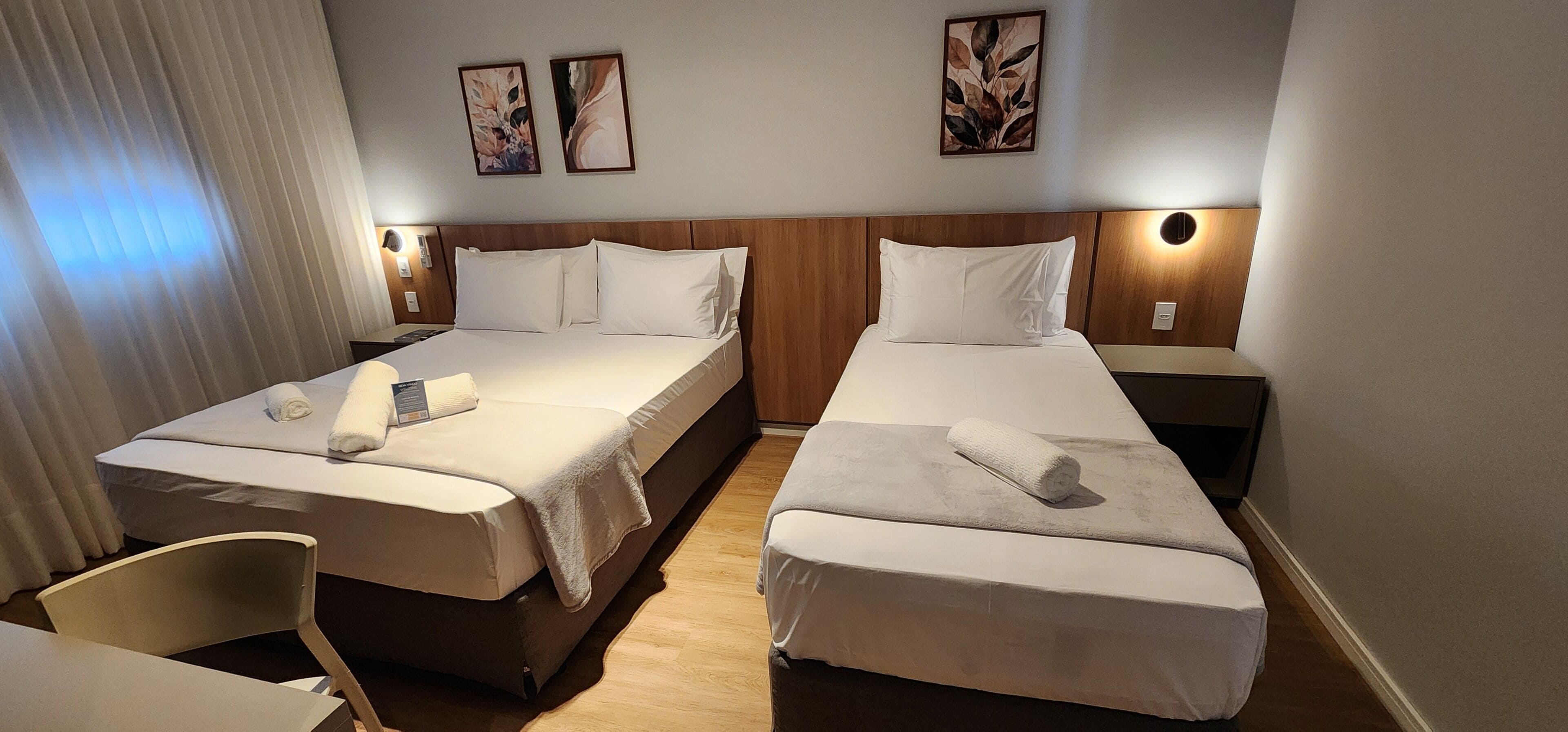 Una habitación de hotel con dos camas, un escritorio y una silla.
