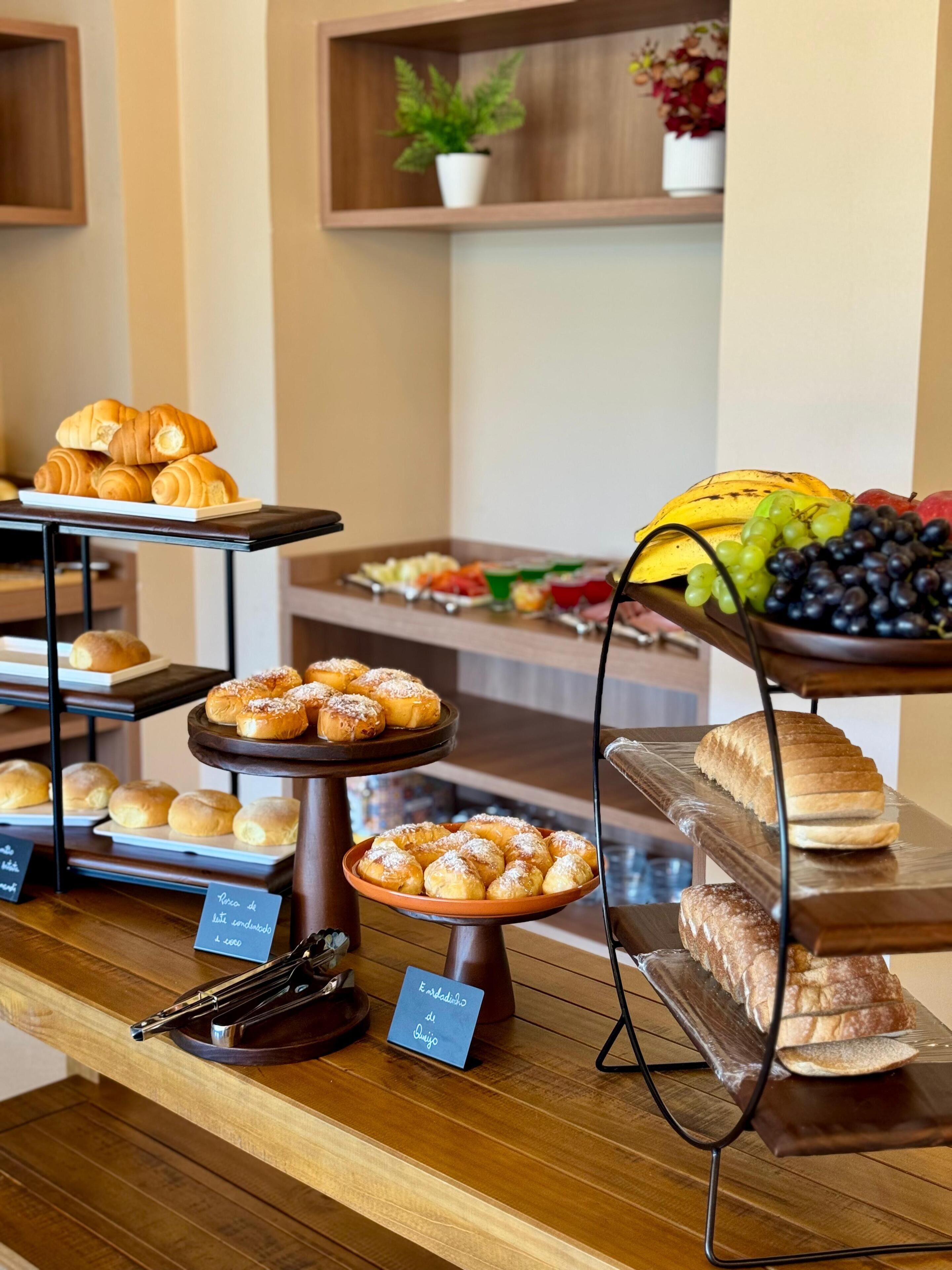 A buffet with various baked goods and fruits.