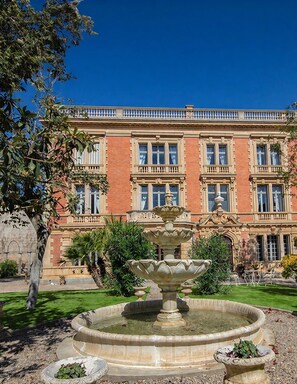 A historic building with a central fountain, surrounded by a well-maintained garden. - Chateau Antares - Eight Bedroom Castle, Sleeps 16 (Marcorignan)