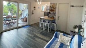 A spacious room with a large bed, a dining area, and a kitchen. - Piccolo Resort sul Conero – Relax con Vista Mare tra Natura e Silenzio (Marche)