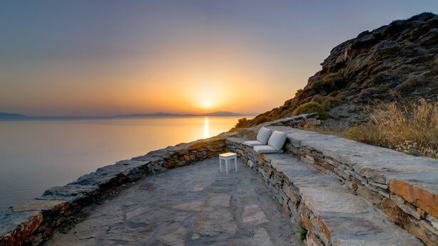 A stone pathway leading to a seating area with a view of the sunset over water. - Villa Kea Royale - Two Bedroom Villa, Sleeps 5 (Kastriani)