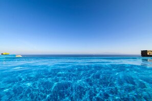 A clear blue pool with a view of the ocean and a rocky outcrop. - Villa Kea Royale - Two Bedroom Villa, Sleeps 5 (Kastriani)