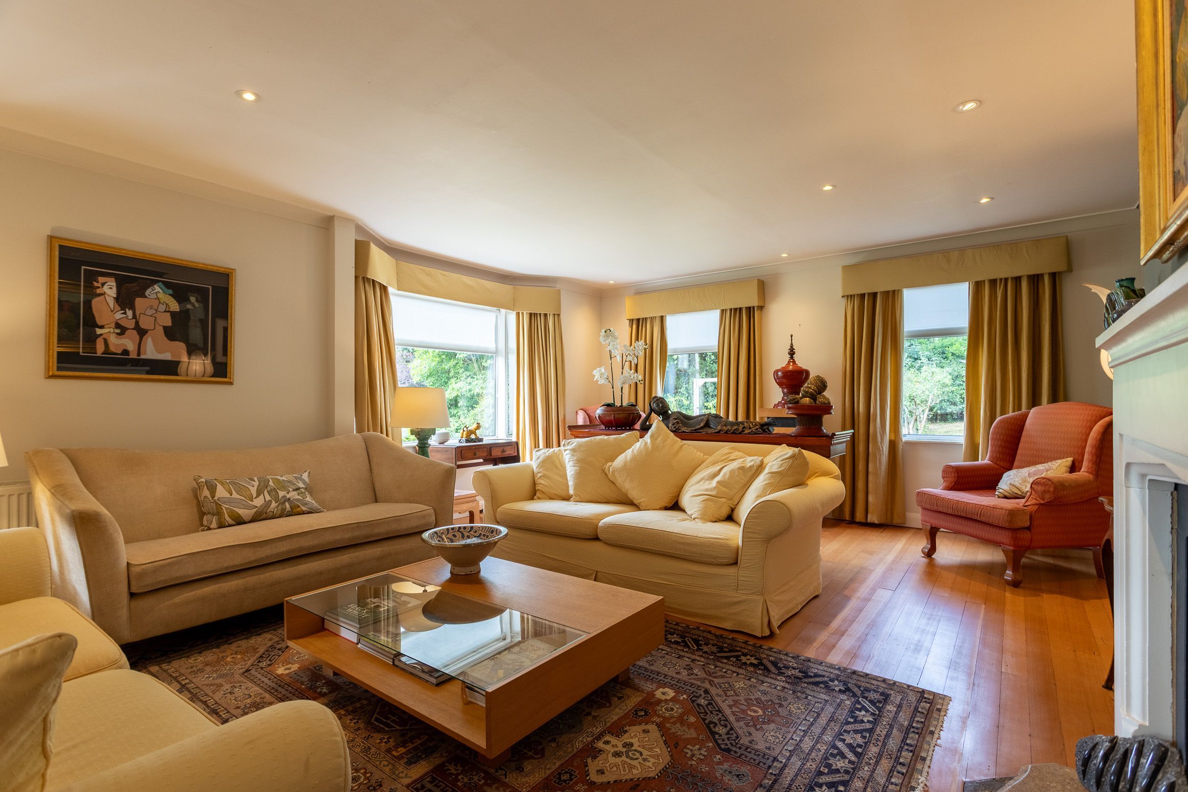 A living room with a sofa, armchairs, a coffee table, and a fireplace.