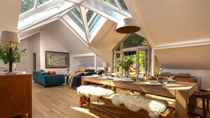 Spazioso loft con tavolo da pranzo in legno, divano e una grande finestra.