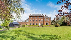 A large brick building with a symmetrical facade, a central entrance, and a well-maintained lawn in front. - Sandon Manor - Seven Bedroom Villa, Sleeps 16 (Sandon)