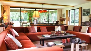 A large, cozy living room with a sectional sofa, a coffee table, and a view of greenery outside. - La Faisane - Five Bedroom Villa, Sleeps 10 (Épaignes)