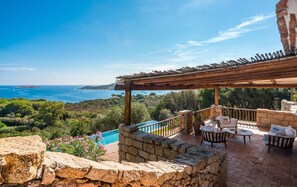 A stone patio with outdoor furniture, a pergola, and a view of the sea. - La Scilla Bianca - Five Bedroom Villa, Sleeps 10 (Pantogia)