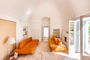 Ein großzügiges Wohnzimmer mit zwei Sofas, einer Lampe und einem Kamin.