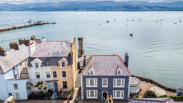 A coastal town with buildings along the waterfront, a pier, and boats in the water. - Spinnaker House - Eight Bedroom Villa, Sleeps 16 (Beaumaris)