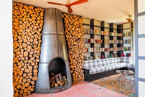 Een moderne woonkamer met een open haard, een boekenkast en een bank.