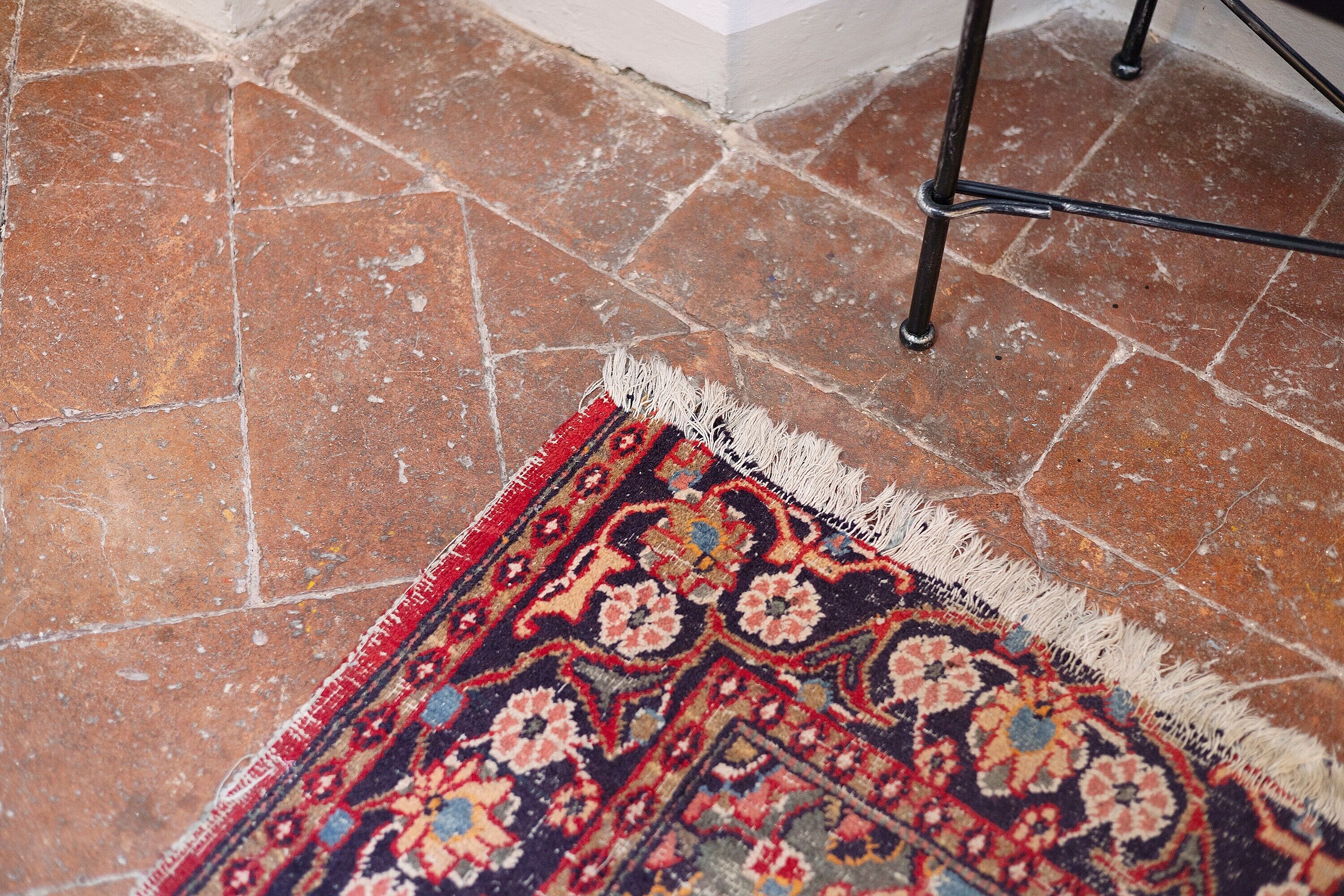 A patterned rug on a tiled floor.
